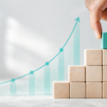 Ein Stapel kleiner Blöcke und eine aufsteigende Wachstumskurve als Symbol für die 1%-Methode und den Aufbau neuer Gewohnheiten.