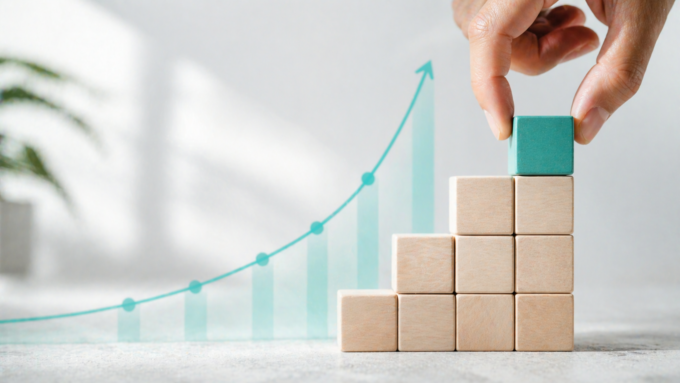 Ein Stapel kleiner Blöcke und eine aufsteigende Wachstumskurve als Symbol für die 1%-Methode und den Aufbau neuer Gewohnheiten.